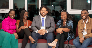 A group of young Black adults sitting together for a photograph.