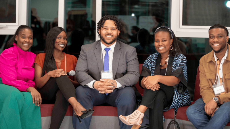 A group of young Black adults sitting together for a photograph.