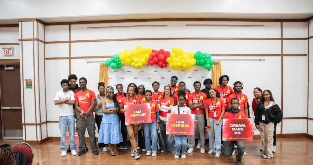 Group of Black youth dressed in read and holding posters for a youth program