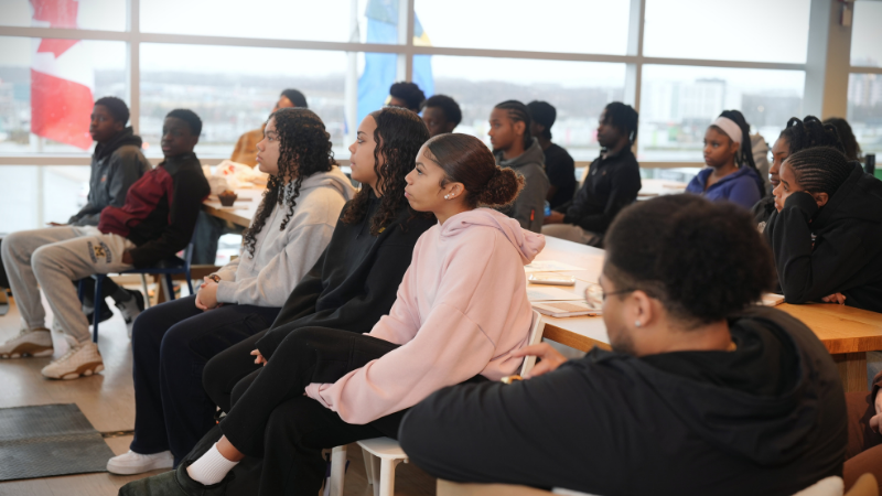 Black youth seated in a group listening to a presentation.