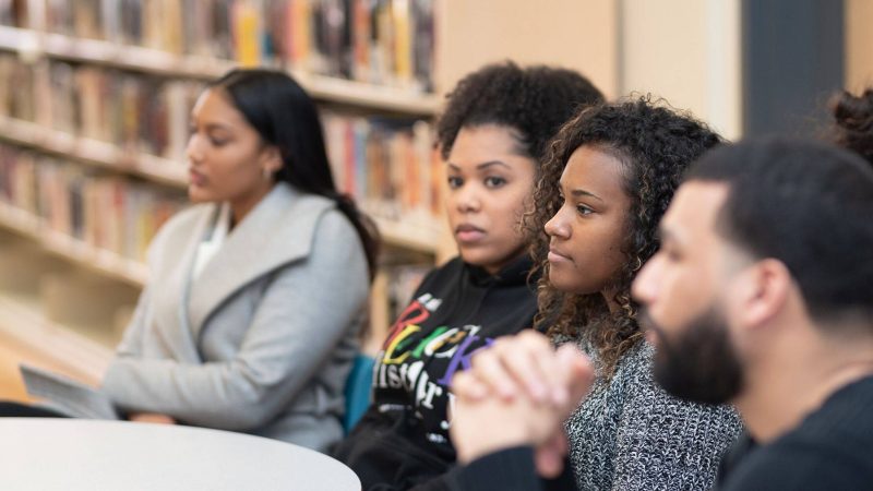 Group of youth sitting at a table listening